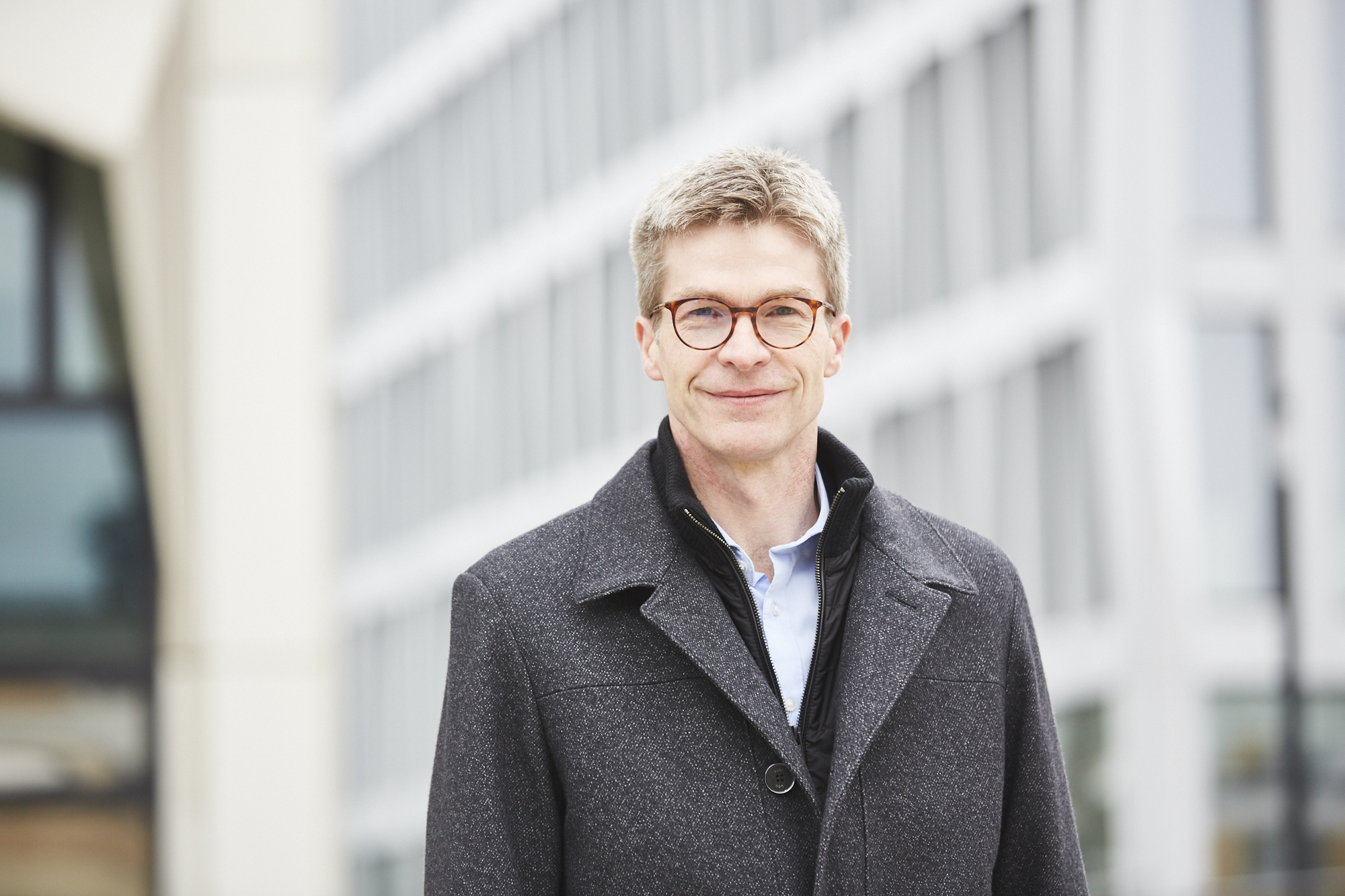Portrait von Prof. Dr. Horst Zisgen vor dem h_da-Hochhaus