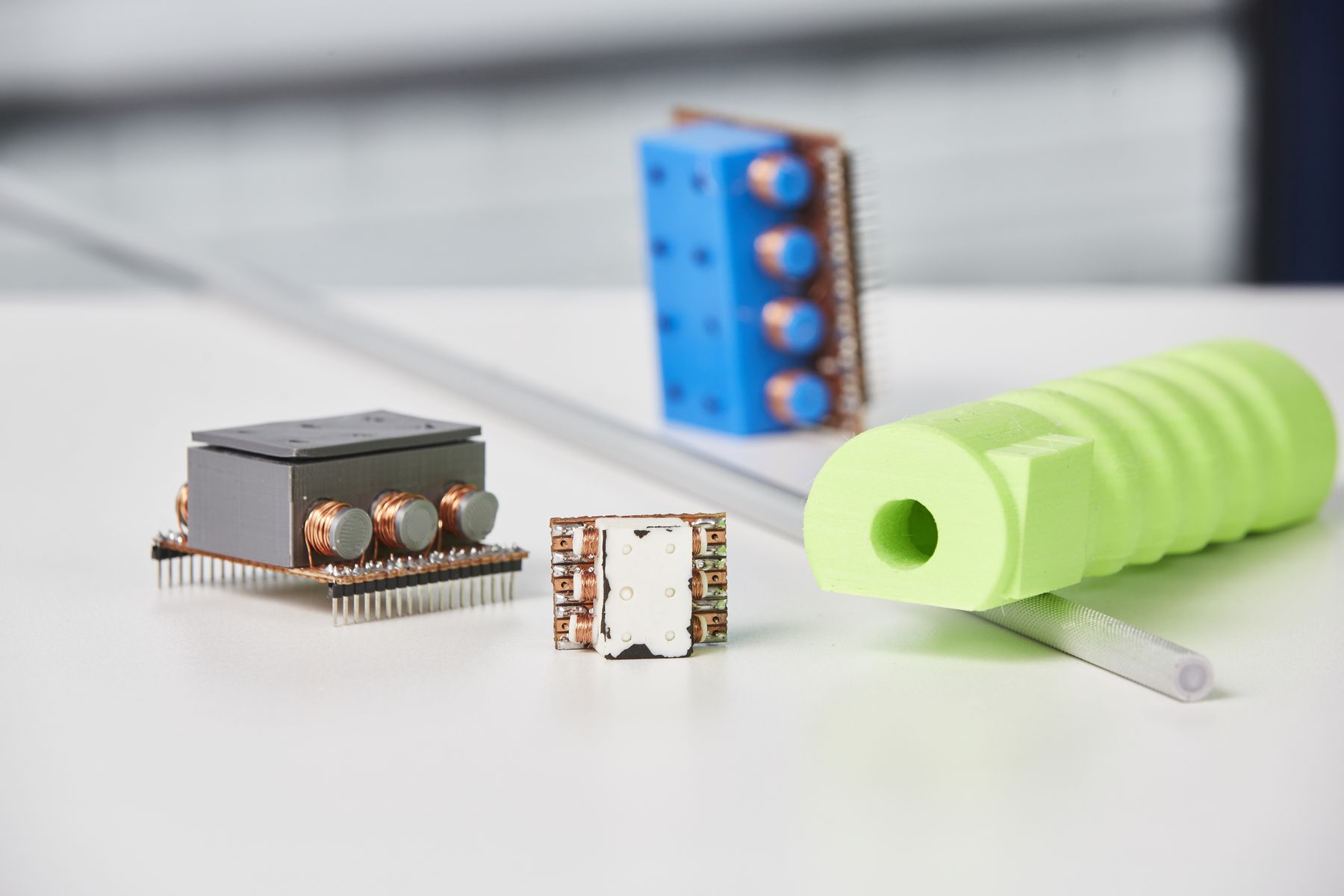 Auf einem weißen Tisch liegen die smarten Bauteile des neuartigen Blindenstocks: die Sensoren und der hellgrüne Griff. 