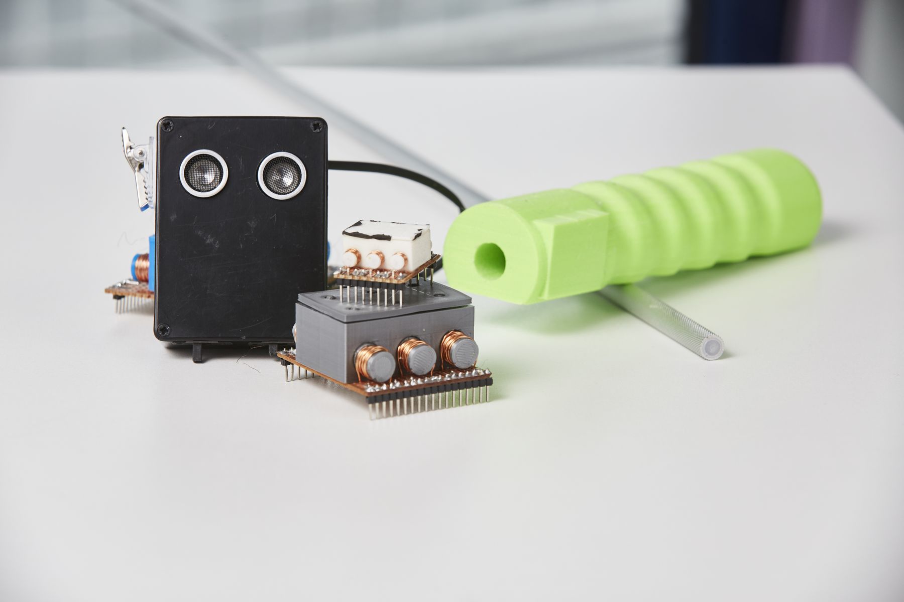 Foto des smarten Blindenstocks mit neongrünem Handgriff, auf einem Tisch liegend