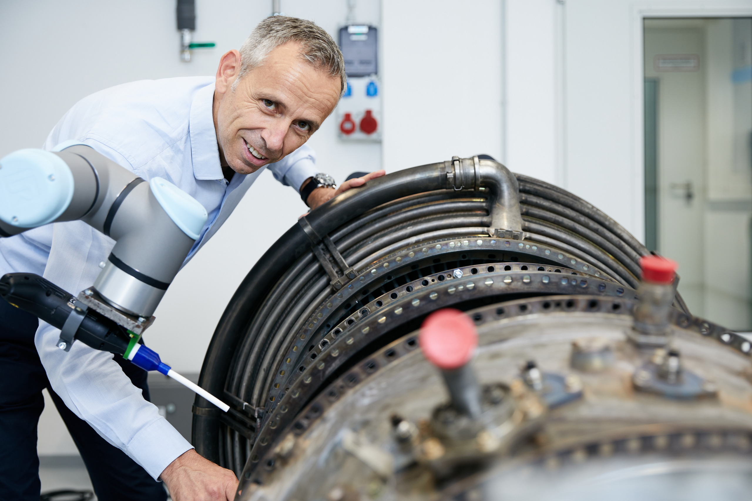 Professor Gerald Ruß trainiert im Labor den Bewegungsablauf eines Roboters für die Reinigung im Heißgasbereich eines Triebwerks