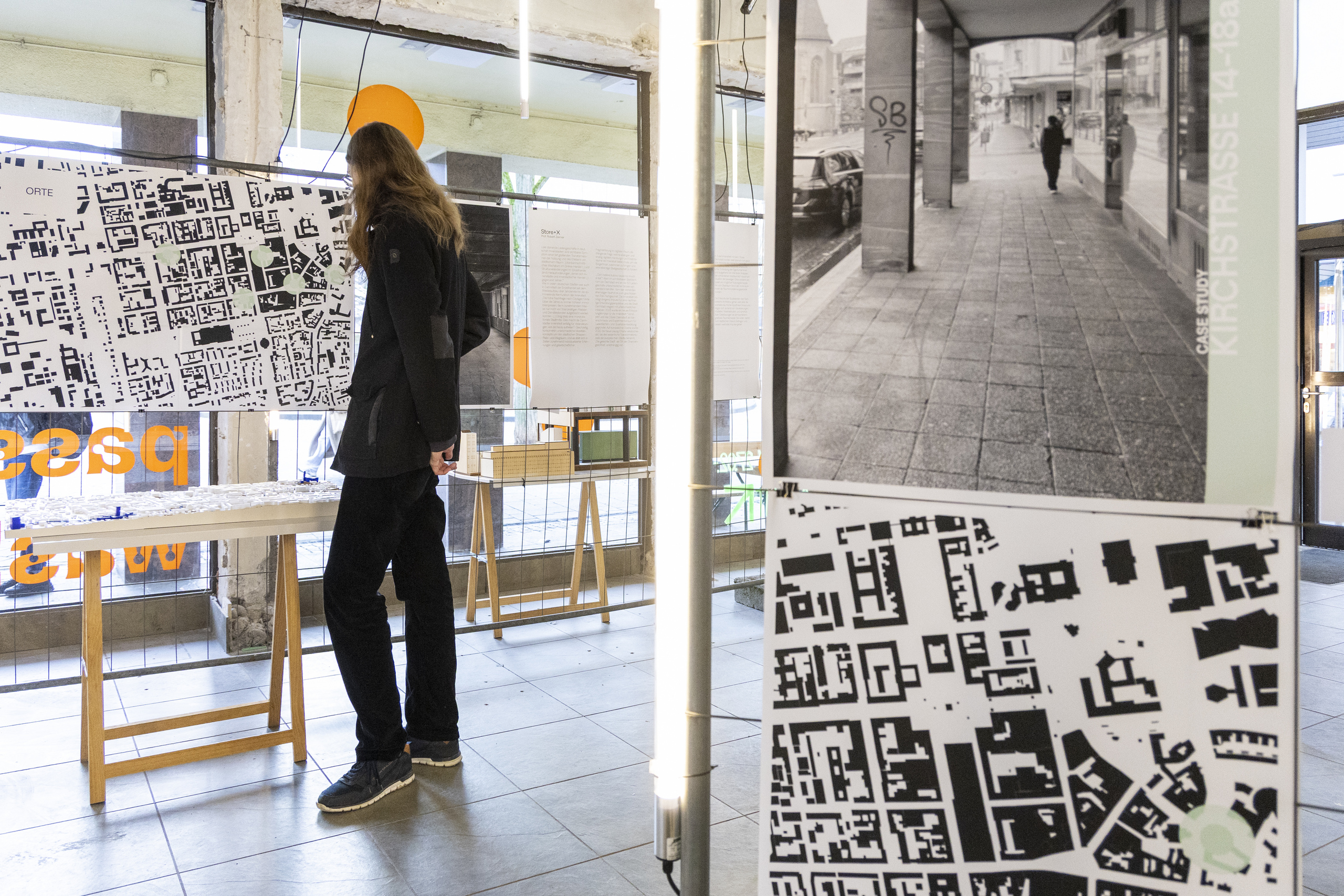 AUsstellungsbesucher vor einem großformatigen PLageplan