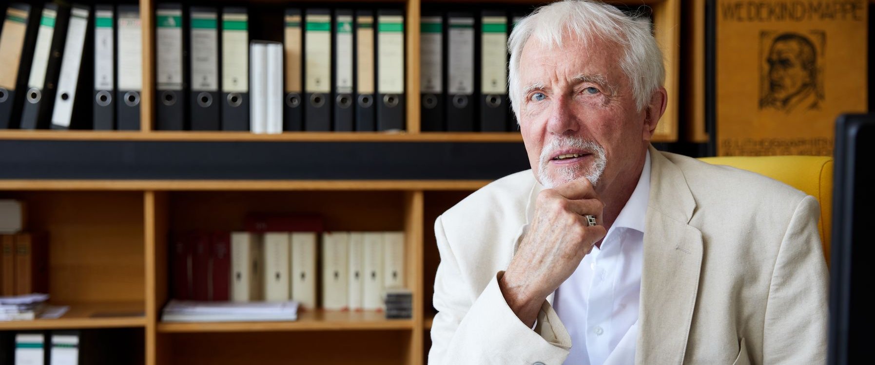 Portraitfoto von Prof. Vincont in seinem Büro, im Hintergrund Bücher und Leitzordner