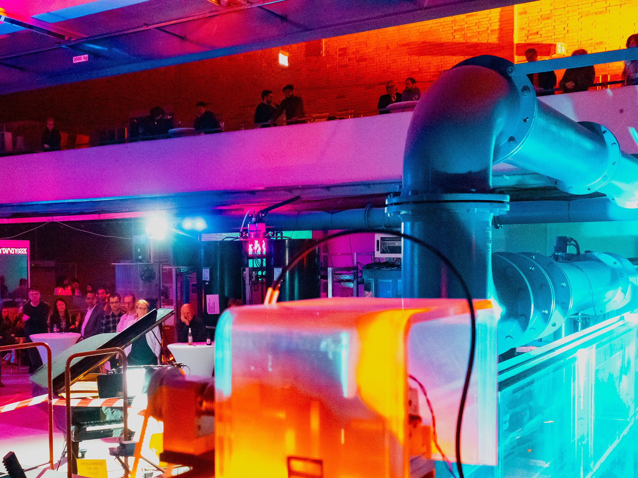 Bunte ausgeleuchtete Halle und Blick auf die Zuschauer am Rand der Konzertfläche