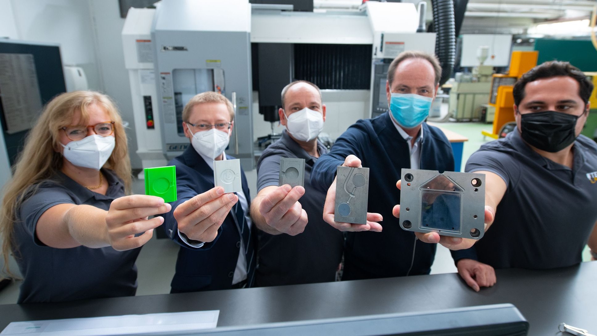 Menschen zeigen Werkstücke