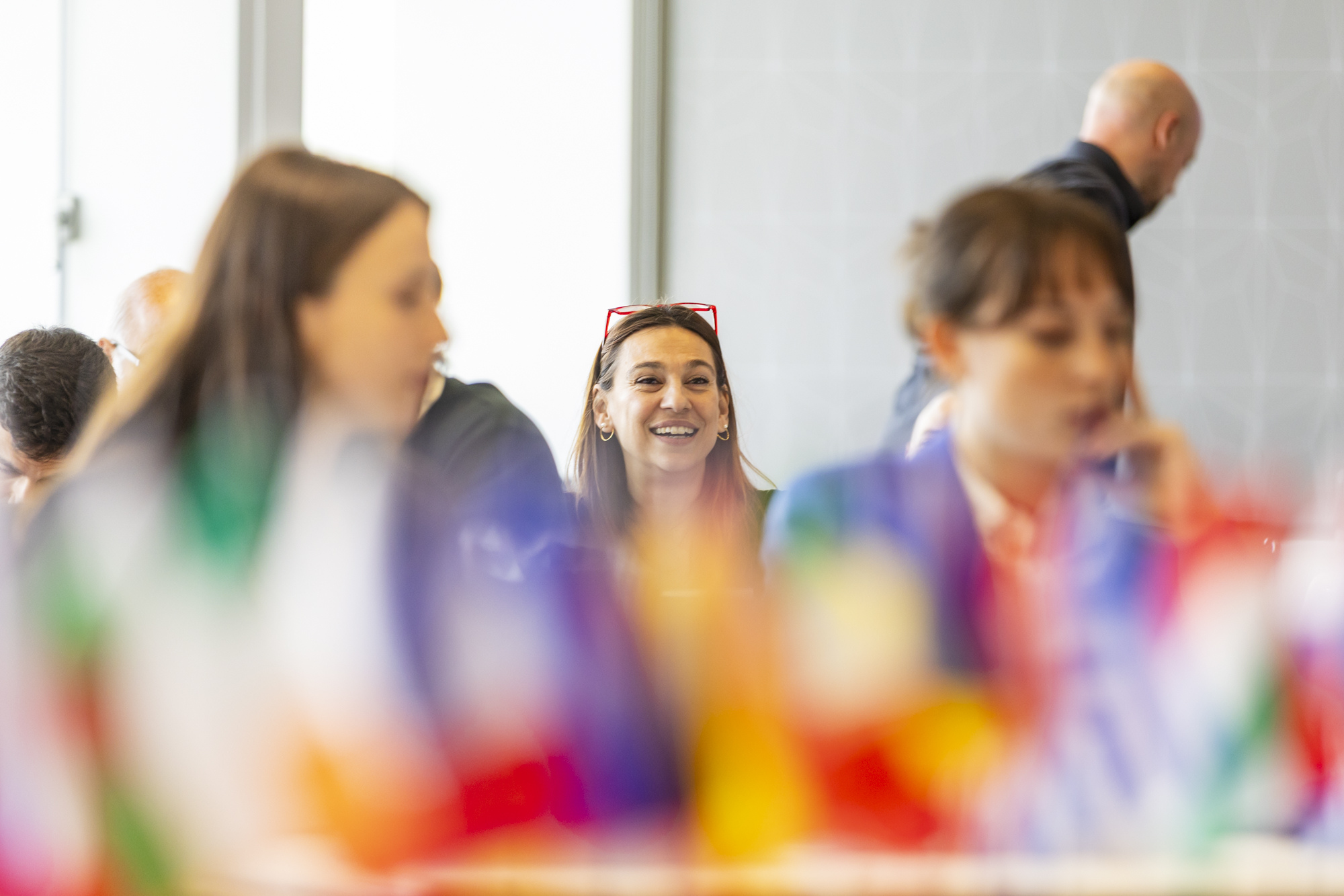 Drei Studentinnen hinter einer Reihe bunter Fähnchen im h_da-Senatsaal