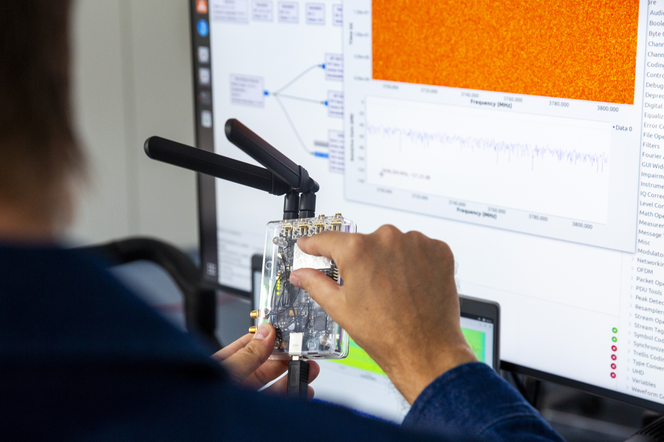 Blick über die Schulter eines Mannes auf einen Bildschirm mit bunten Grafiken