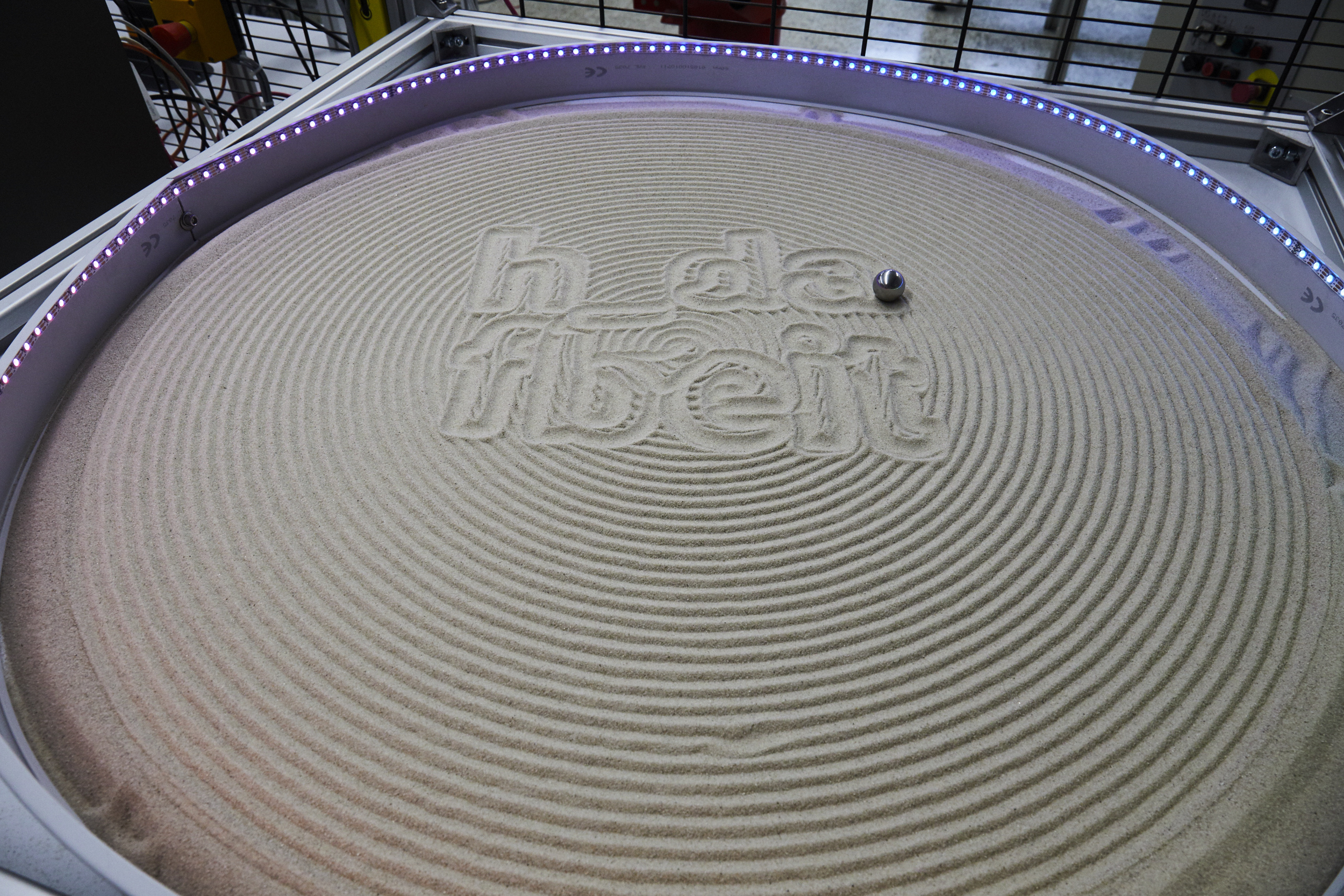 Rundes Sandfeld mit h_da-Logo in der Mitte