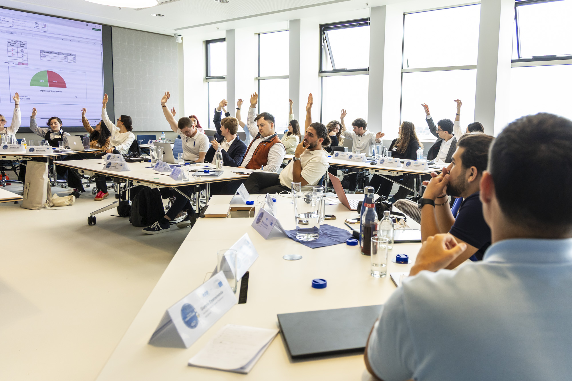 Abstimmung - Studierende im Plenum mit gehobenen Händen