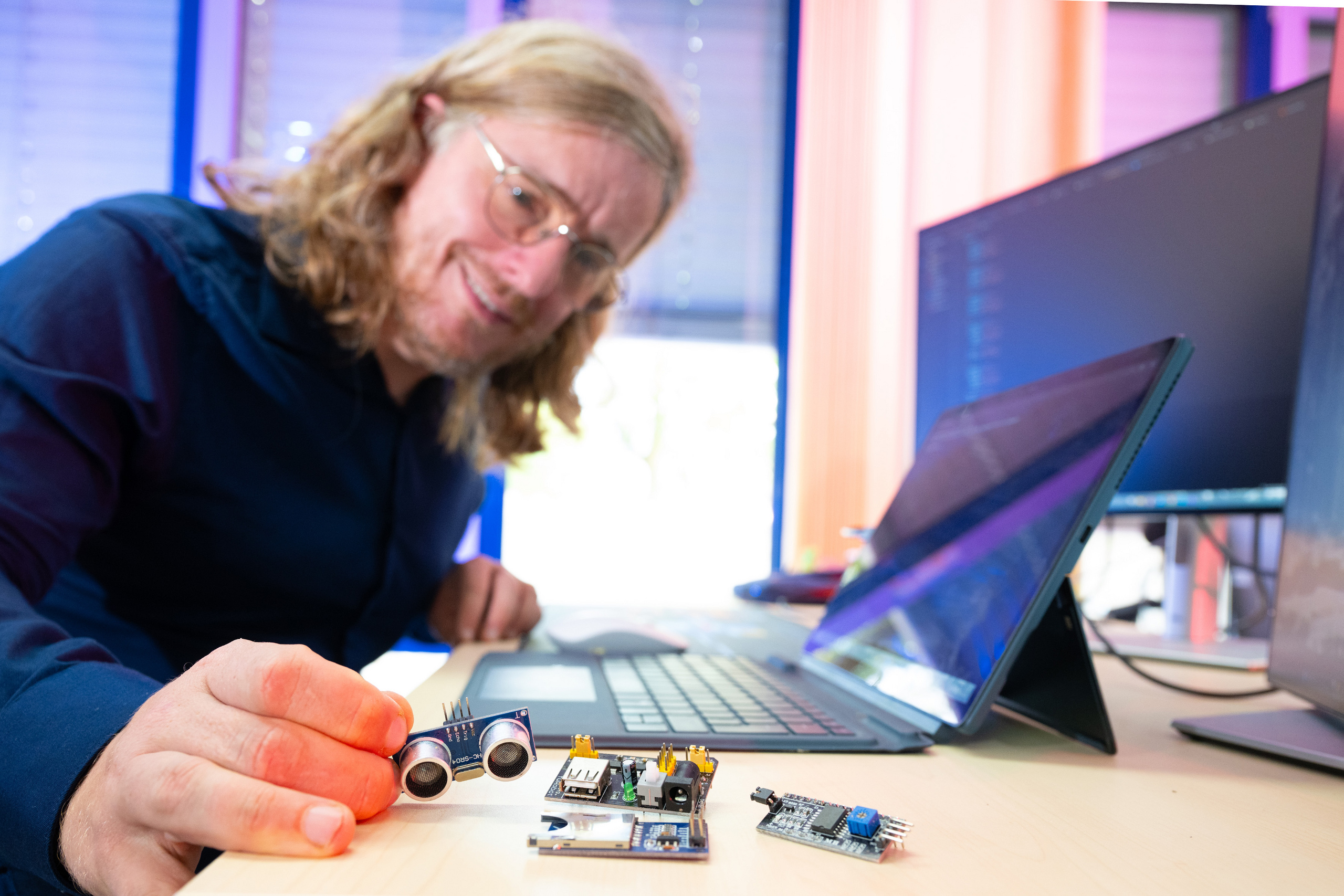 Professor Zinn am Schreibtisch mit Laptop und technischem Equipment