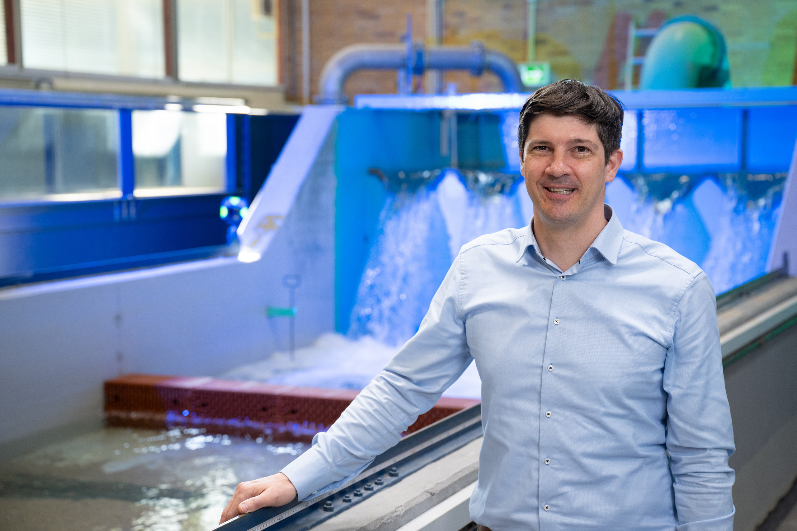 Portrait von Prof. Hack in der blau illuminierten Wasserbauhalle